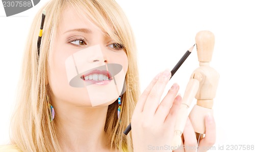 Image of happy teenage girl with wooden model dummy