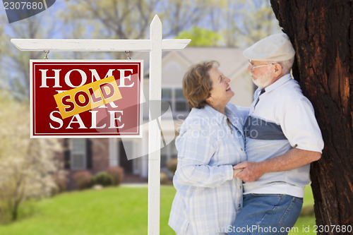 Image of Sold Real Estate Sign with Senior Couple in Front of House