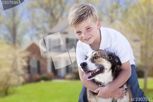 Image of Young Boy and His Dog in Front of House