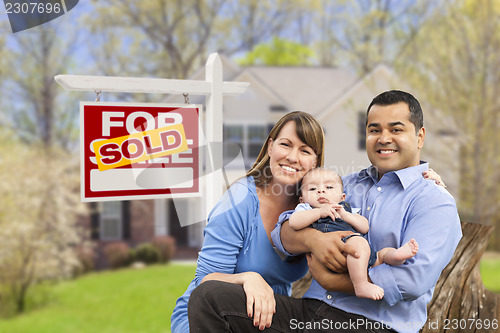 Image of Young Family in Front of Sold Real Estate Sign and House