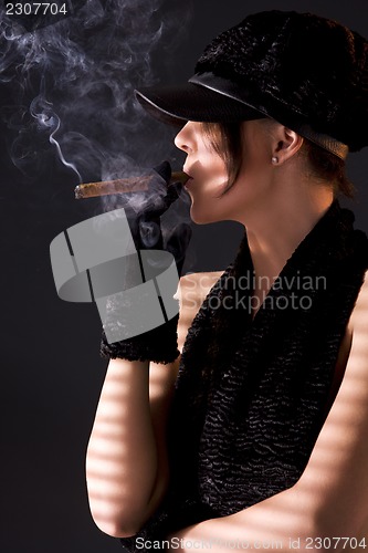 Image of woman in black astrakhan smoking cigar