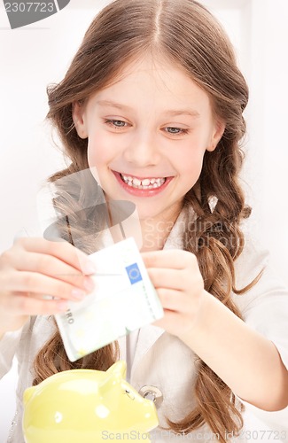 Image of little girl with piggy bank and money