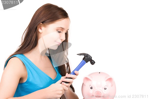 Image of teenage girl with piggy bank and hammer