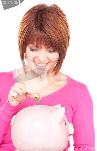 Image of lovely woman with piggy bank and money