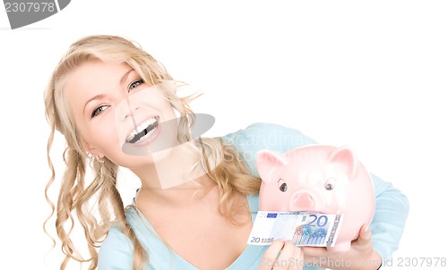 Image of lovely woman with piggy bank and money