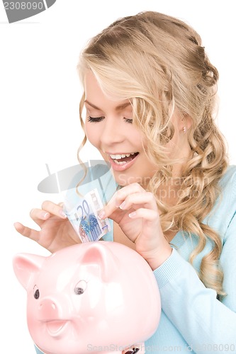 Image of lovely woman with piggy bank and money