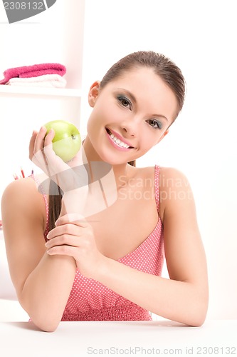 Image of young beautiful woman with green apple