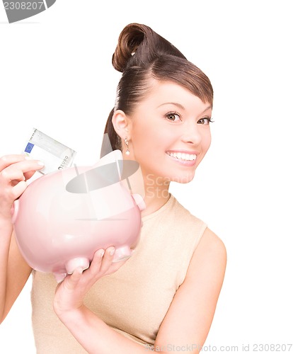 Image of lovely woman with piggy bank and money