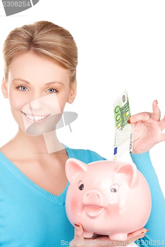 Image of lovely woman with piggy bank and money