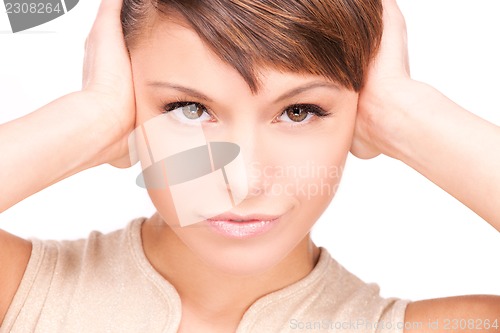 Image of unhappy woman with hands on ears
