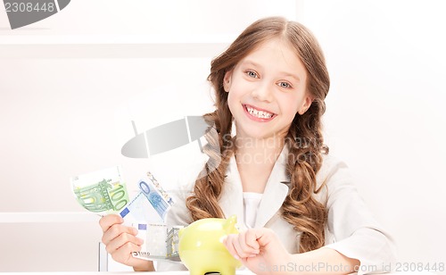 Image of little girl with piggy bank and money