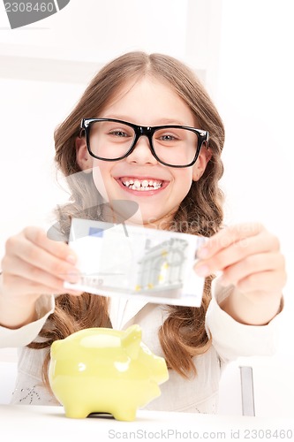 Image of little girl with piggy bank and money