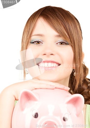 Image of lovely teenage girl with piggy bank