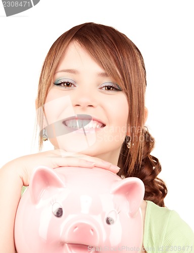 Image of lovely teenage girl with piggy bank