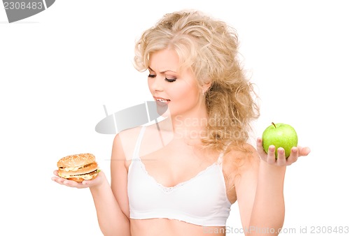Image of woman choosing between burger and apple