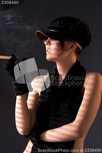 Image of woman in black astrakhan smoking cigar