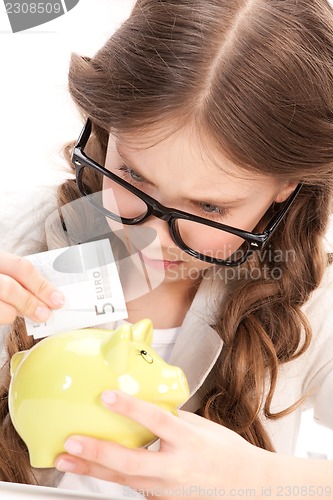 Image of little girl with piggy bank and money