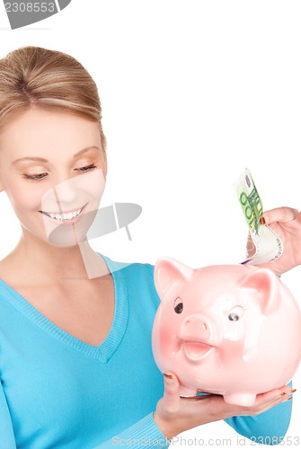 Image of lovely woman with piggy bank and money
