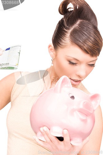 Image of lovely woman with piggy bank and money
