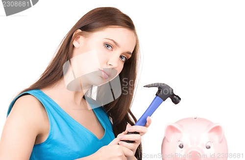 Image of teenage girl with piggy bank and hammer