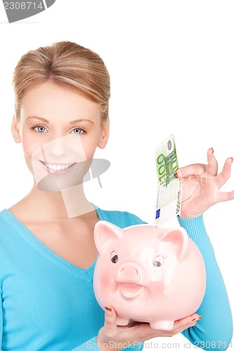 Image of lovely woman with piggy bank and money