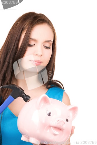 Image of teenage girl with piggy bank and hammer