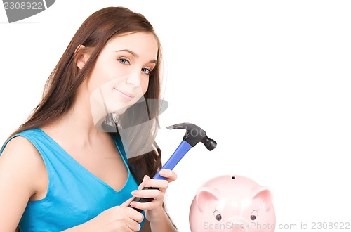 Image of teenage girl with piggy bank and hammer