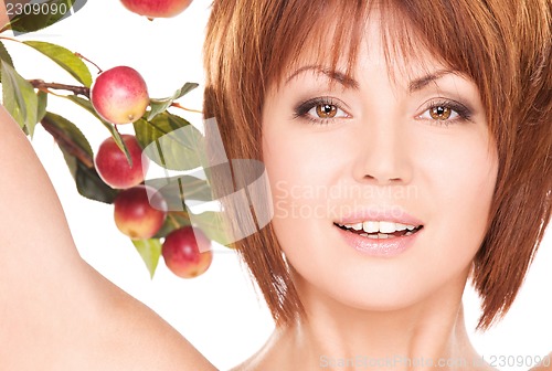Image of happy woman with apple twig