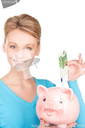 Image of lovely woman with piggy bank and money