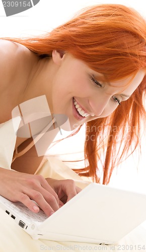 Image of happy redhead woman with laptop computer