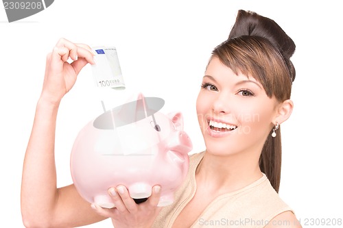 Image of lovely woman with piggy bank and money