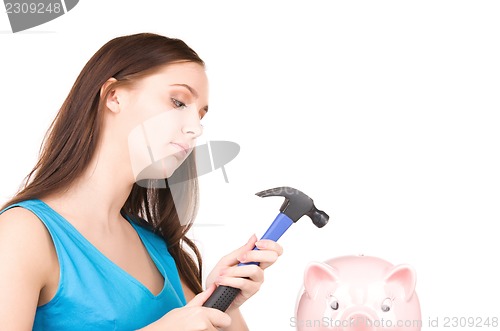 Image of teenage girl with piggy bank and hammer