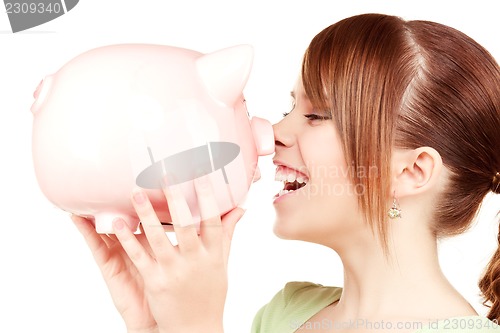 Image of lovely teenage girl with piggy bank