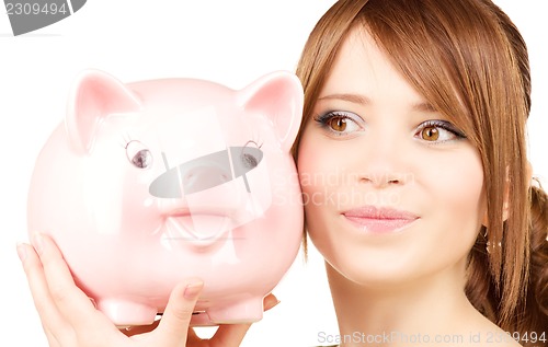 Image of lovely teenage girl with piggy bank