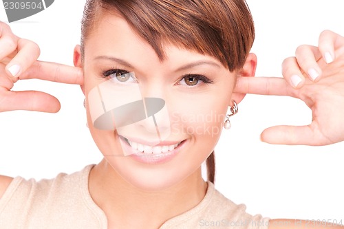 Image of smiling woman with fingers in ears