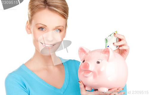 Image of lovely woman with piggy bank and money