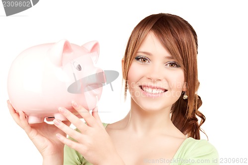 Image of lovely teenage girl with piggy bank