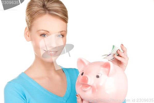 Image of lovely woman with piggy bank and money