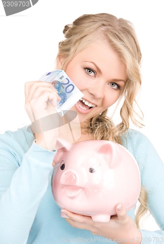 Image of lovely woman with piggy bank and money