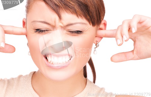 Image of unhappy woman with fingers in ears