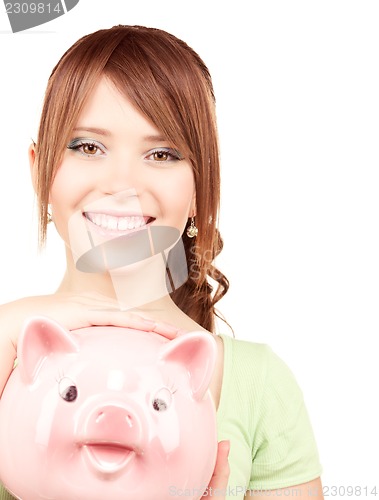 Image of lovely teenage girl with piggy bank