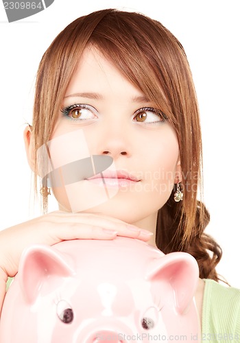 Image of lovely teenage girl with piggy bank