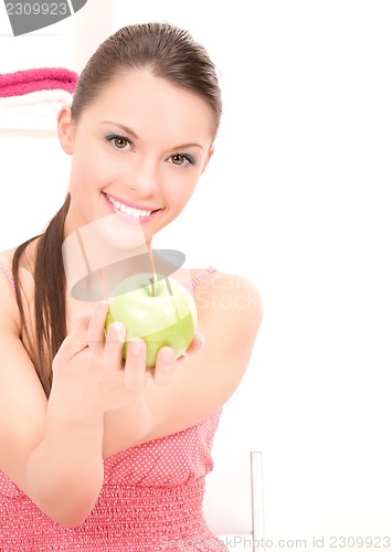 Image of young beautiful woman with green apple