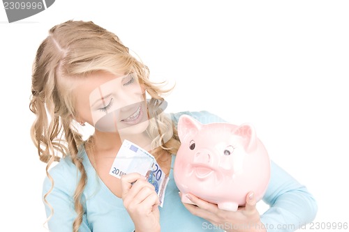 Image of lovely woman with piggy bank and money