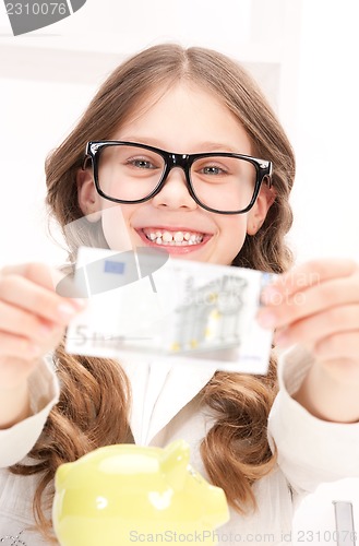 Image of little girl with piggy bank and money