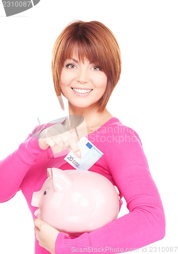 Image of lovely woman with piggy bank and money