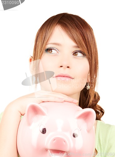 Image of lovely teenage girl with piggy bank