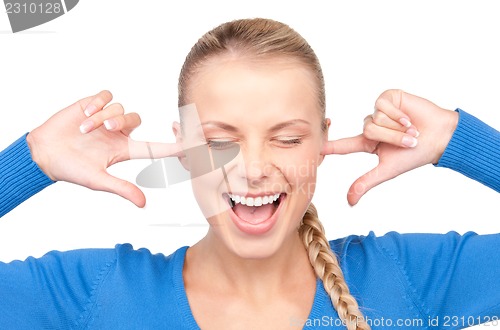 Image of smiling woman with fingers in ears