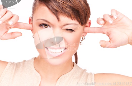 Image of smiling woman with fingers in ears