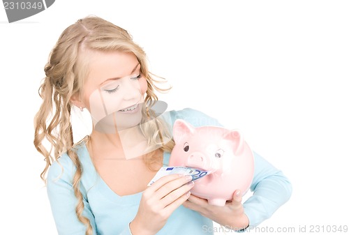 Image of lovely woman with piggy bank and money